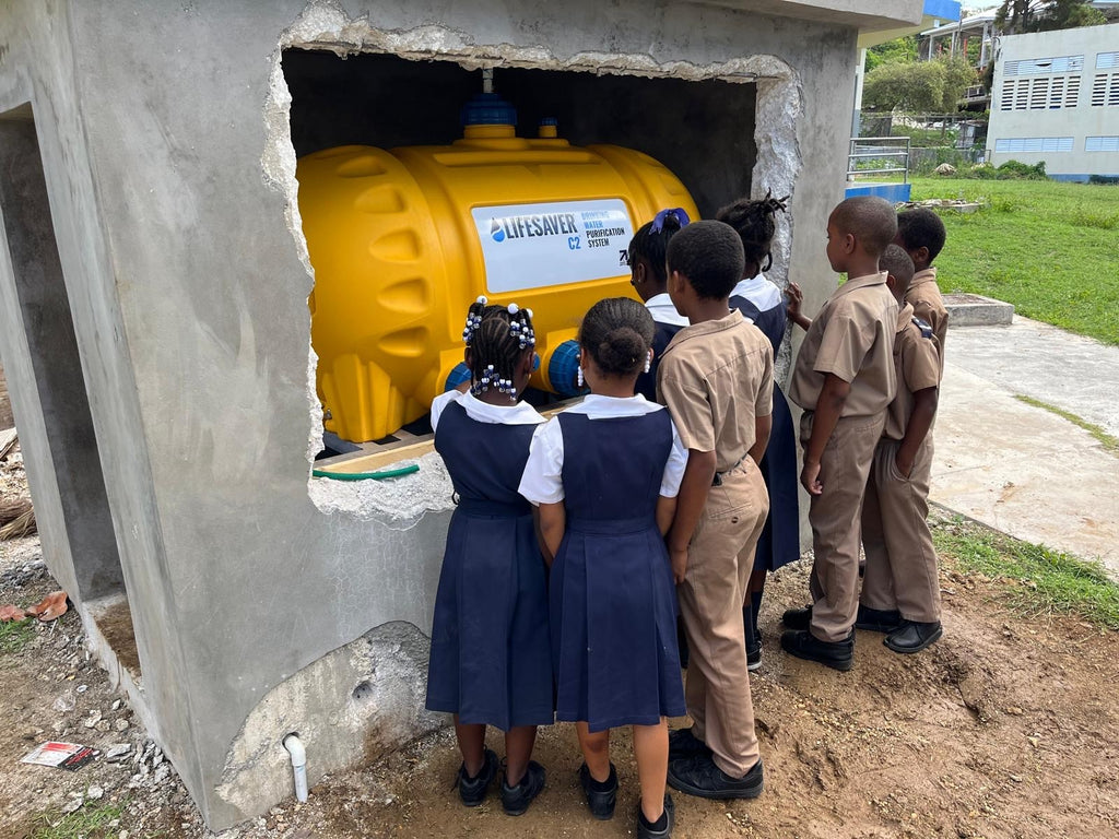 Carribean school children crowding around a LifeSaver C2 water purifier