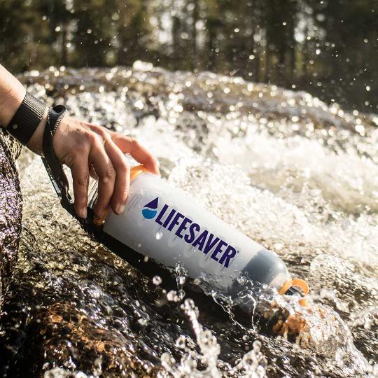 Laden Sie das Bild in Galerie -Viewer, LifeSaver water purifier bottle being used to filter moving river water
