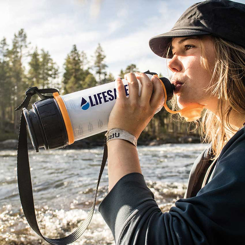 Laden Sie das Bild in Galerie -Viewer, Girl drinking from the LifeSaver 4000UF Bottle by a river in Sweden
